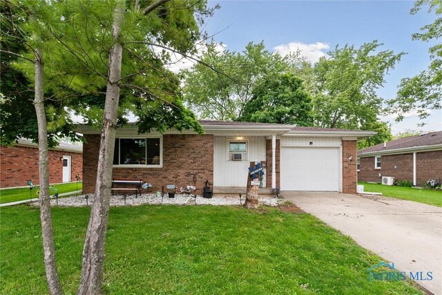 417 Indian Rd, Wauseon, OH 43567 - view of front facade with a garage, brick siding, and a front yard