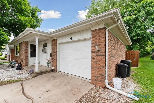 417 Indian Rd, Wauseon, OH 43567 - view of front of property with concrete driveway, brick siding, and an attached garage