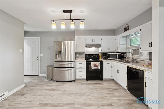417 Indian Rd, Wauseon, OH 43567 - kitchen featuring black appliances, baseboard heating, light countertops, and white cabinetry