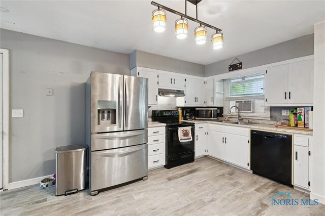 417 Indian Rd, Wauseon, OH 43567 - kitchen featuring black appliances, under cabinet range hood, a sink, light countertops, and light wood finished floors