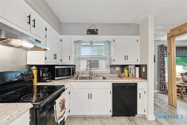 417 Indian Rd, Wauseon, OH 43567 - kitchen featuring black appliances, under cabinet range hood, white cabinets, a sink, and light wood finished floors
