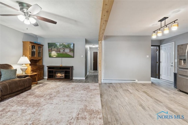 417 Indian Rd, Wauseon, OH 43567 - living room featuring baseboard heating, baseboards, ceiling fan, and wood finished floors