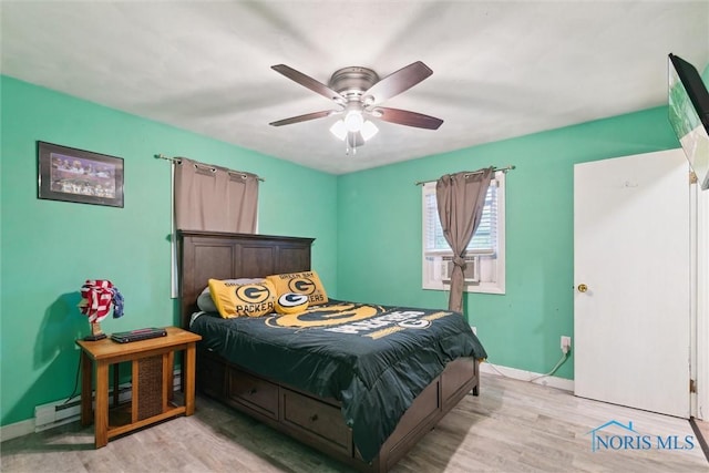 417 Indian Rd, Wauseon, OH 43567 - bedroom featuring light wood-style flooring, baseboards, cooling unit, a ceiling fan, and a baseboard heating unit