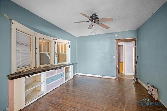 unfurnished living room featuring wood finished floors, ceiling fan, and baseboards
