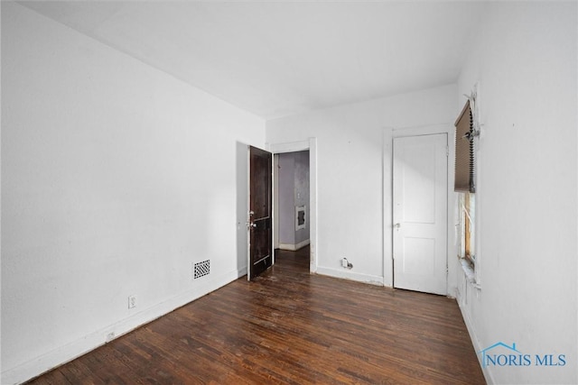 unfurnished bedroom with wood finished floors and baseboards