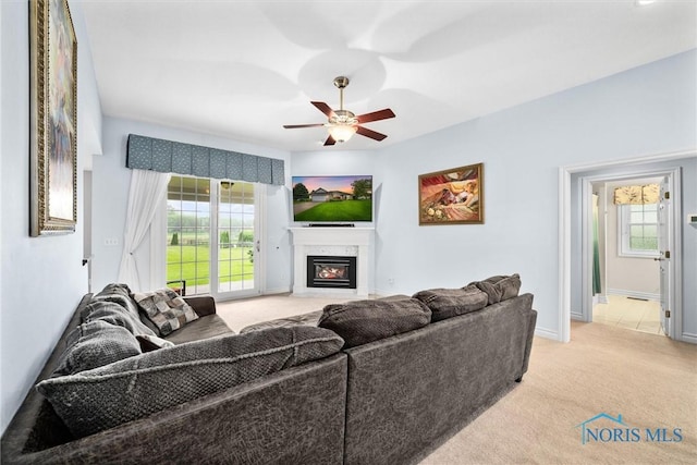 5723 Timbers Grn, Waterville, OH 43566 - living area featuring light colored carpet, a glass covered fireplace, healthy amount of natural light, and a ceiling fan