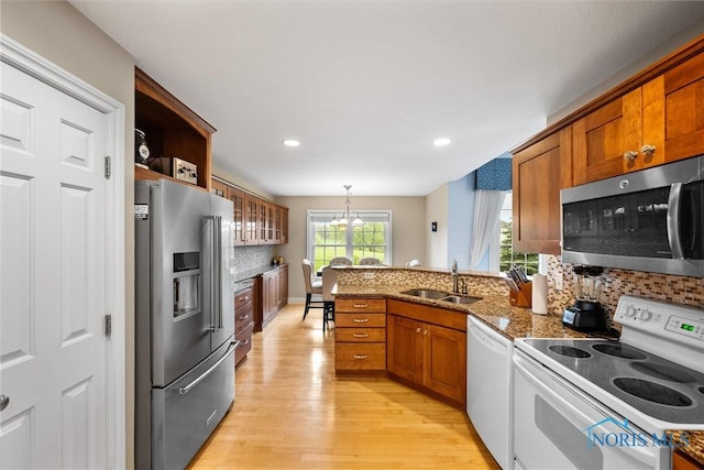 5723 Timbers Grn, Waterville, OH 43566 - kitchen featuring stainless steel appliances, a sink, light wood-style floors, brown cabinets, and a peninsula