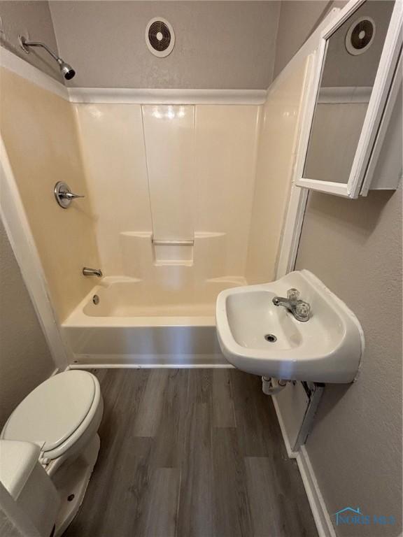 3907 Lagrange St, Toledo, OH 43612 - full bathroom featuring wood finished floors, toilet, a sink, and  shower combination