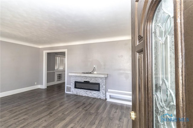 4202 Asbury Dr, Toledo, OH 43612 - unfurnished living room with baseboards, dark wood-style floors, and a stone fireplace