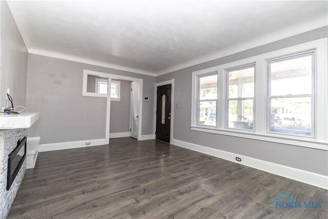 4202 Asbury Dr, Toledo, OH 43612 - unfurnished living room with baseboards, dark wood finished floors, and a stone fireplace
