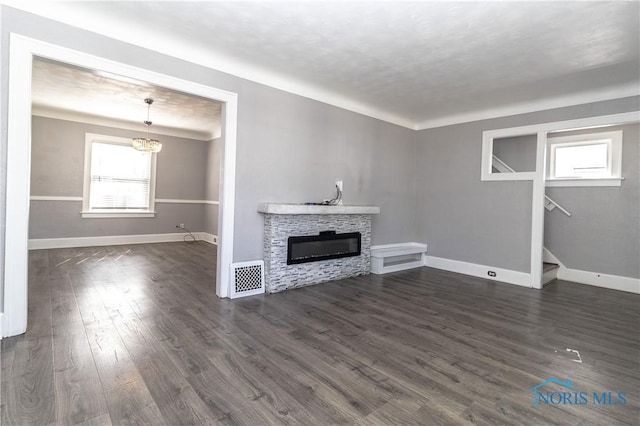 4202 Asbury Dr, Toledo, OH 43612 - unfurnished living room with healthy amount of natural light, a fireplace, dark wood-style flooring, and baseboards