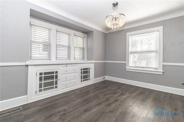 4202 Asbury Dr, Toledo, OH 43612 - unfurnished room with a chandelier, dark wood-style floors, and baseboards