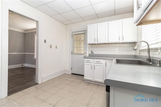 4202 Asbury Dr, Toledo, OH 43612 - kitchen featuring a sink, white cabinetry, tasteful backsplash, a drop ceiling, and baseboards