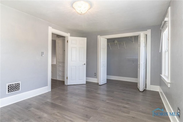 4202 Asbury Dr, Toledo, OH 43612 - unfurnished bedroom featuring wood finished floors, a closet, baseboards, and multiple windows