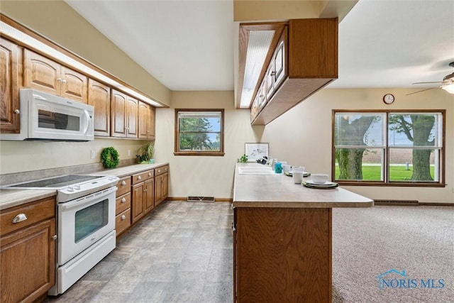 2454 Adams Ridge Rd, Defiance, OH 43512 - kitchen featuring white appliances, baseboards, a sink, a ceiling fan, and brown cabinetry