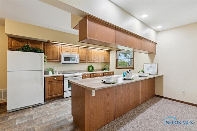 2454 Adams Ridge Rd, Defiance, OH 43512 - kitchen with white appliances, a peninsula, light countertops, baseboards, and brown cabinets