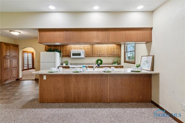 2454 Adams Ridge Rd, Defiance, OH 43512 - kitchen with white appliances, arched walkways, light countertops, brown cabinets, and carpet floors