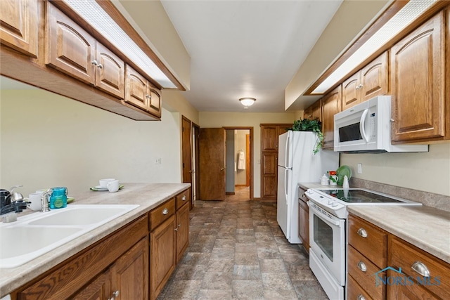 2454 Adams Ridge Rd, Defiance, OH 43512 - kitchen with white appliances, a sink, stone finish flooring, light countertops, and brown cabinetry