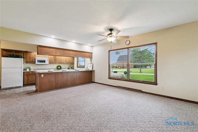 2454 Adams Ridge Rd, Defiance, OH 43512 - kitchen with white appliances, brown cabinets, light countertops, a peninsula, and healthy amount of natural light