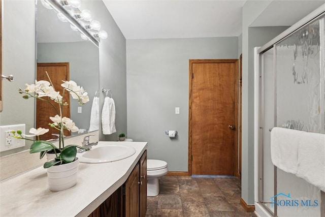 2454 Adams Ridge Rd, Defiance, OH 43512 - bathroom with stone finish flooring, baseboards, a shower stall, vanity, and toilet