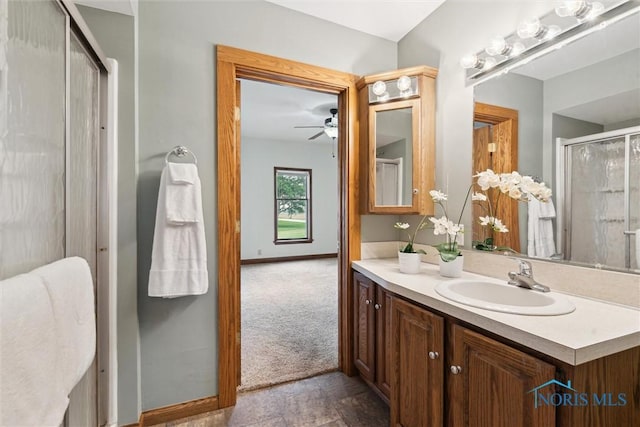 2454 Adams Ridge Rd, Defiance, OH 43512 - bathroom with ceiling fan, vanity, a shower with shower door, stone finish flooring, and baseboards