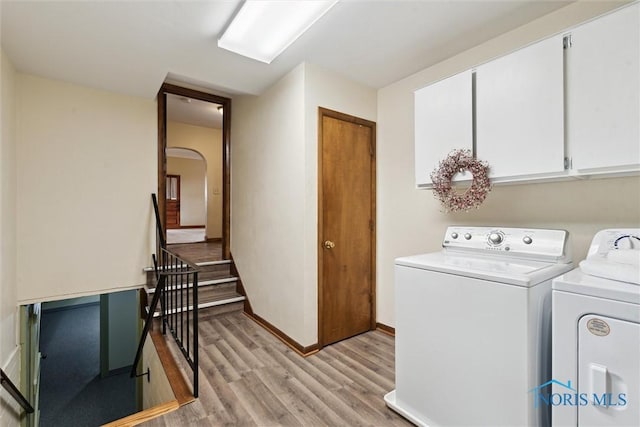 2454 Adams Ridge Rd, Defiance, OH 43512 - laundry room with separate washer and dryer, cabinet space, light wood-style floors, arched walkways, and baseboards