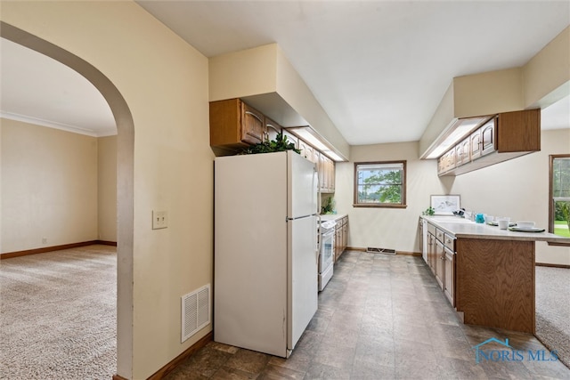 2454 Adams Ridge Rd, Defiance, OH 43512 - kitchen featuring white appliances, baseboards, arched walkways, brown cabinets, and light countertops