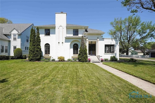 218 E Mcpherson Ave, Findlay, OH 45840 - view of front facade with stucco siding, a front lawn, and a chimney