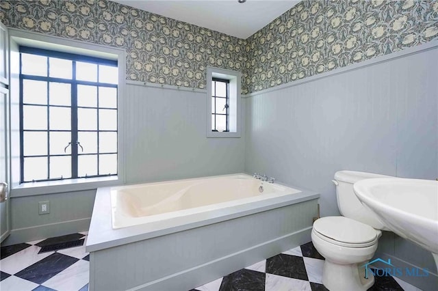 218 E Mcpherson Ave, Findlay, OH 45840 - bathroom with a bath, toilet, baseboards, wallpapered walls, and wainscoting