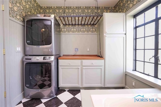 218 E Mcpherson Ave, Findlay, OH 45840 - washroom with stacked washer and clothes dryer, wallpapered walls, and cabinet space