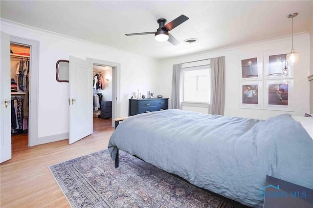 218 E Mcpherson Ave, Findlay, OH 45840 - bedroom with a walk in closet, crown molding, light wood-style flooring, baseboards, and a closet