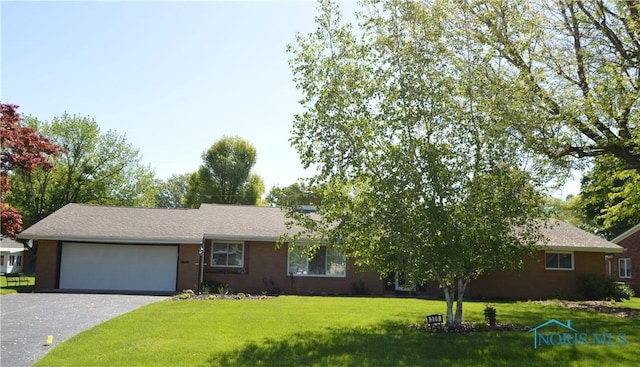 309 Huron Rd, Findlay, OH 45840 - ranch-style house featuring a garage, asphalt driveway, and a front yard