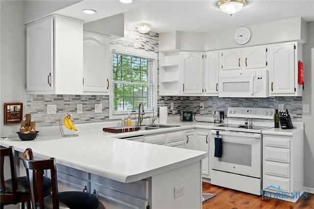 805 N Hill Trl, Findlay, OH 45840 - kitchen featuring white appliances, a peninsula, a sink, a kitchen breakfast bar, and white cabinets