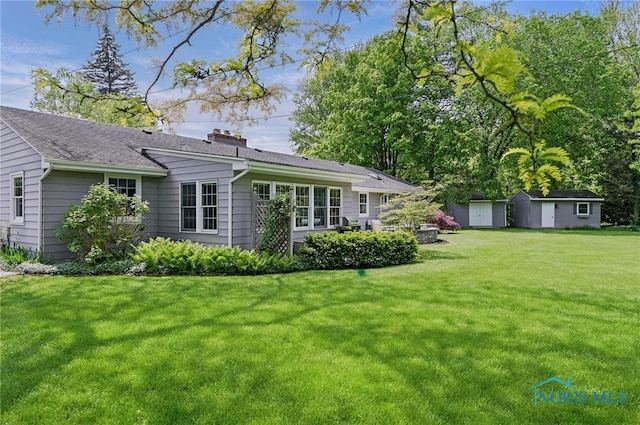 125 Carolin Ct, Perrysburg, OH 43551 - rear view of property featuring an outdoor structure, a yard, a storage shed, a chimney, and a shingled roof