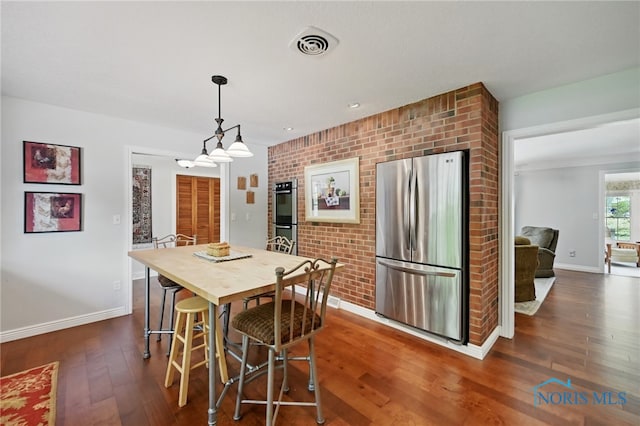 125 Carolin Ct, Perrysburg, OH 43551 - dining area with baseboards, dark wood finished floors, and brick wall