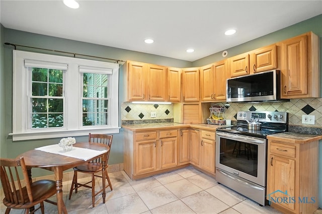 232 E Wayne St, Maumee, OH 43537 - kitchen with stainless steel electric stove, decorative backsplash, light tile patterned floors, recessed lighting, and light brown cabinets