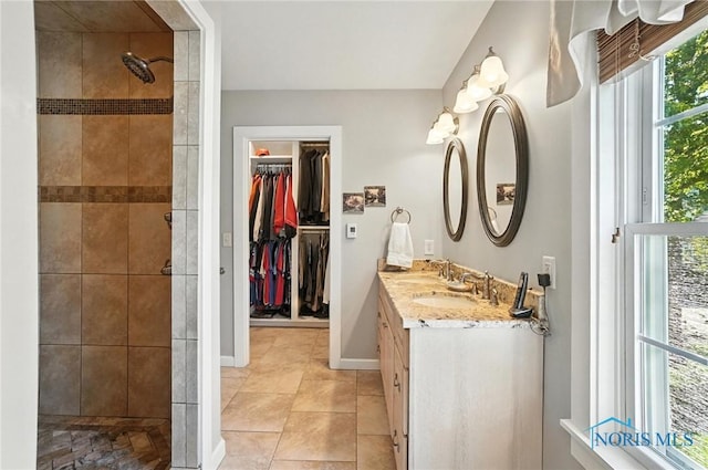 232 E Wayne St, Maumee, OH 43537 - bathroom featuring double vanity, tiled shower, a spacious closet, and tile patterned floors