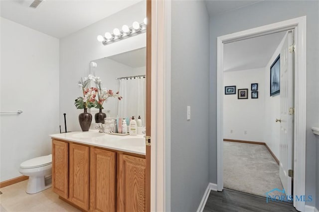 548 Niagara Ave, Holland, OH 43528 - full bathroom featuring double vanity, toilet, baseboards, and wood finished floors