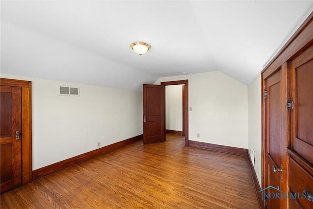 431 W Ottawa St, Oak Harbor, OH 43449 - additional living space with baseboards, vaulted ceiling, and light wood finished floors