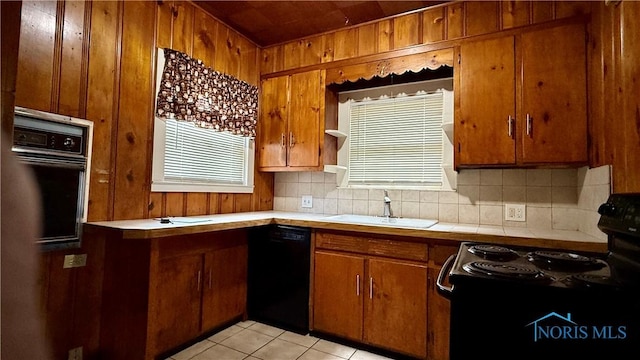 2659 Oak Grove Pl, Toledo, OH 43613 - kitchen featuring black appliances, a sink, tasteful backsplash, brown cabinets, and wooden walls