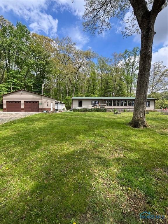 11555 Manore Rd, Grand Rapids, OH 43522 - view of front of home with a garage, a front lawn, and dirt driveway