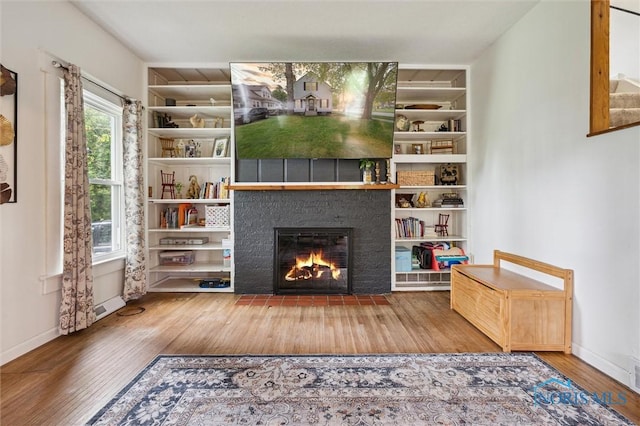 3555 Island Ave, Toledo, OH 43614 - living area with wood finished floors, a fireplace with flush hearth, built in features, and baseboards