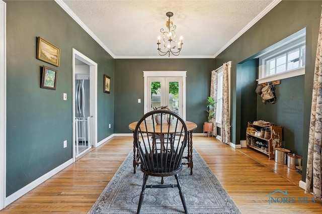 3555 Island Ave, Toledo, OH 43614 - dining area with plenty of natural light, a chandelier, french doors, light wood-style floors, and crown molding