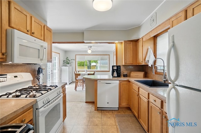 kitchen featuring white appliances, a sink, light countertops, and tasteful backsplash