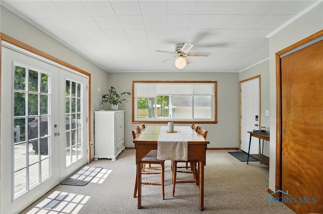 dining room featuring plenty of natural light, french doors, light colored carpet, and crown molding