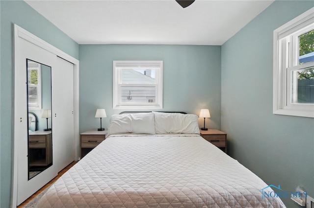 bedroom featuring wood finished floors, ceiling fan, and a closet