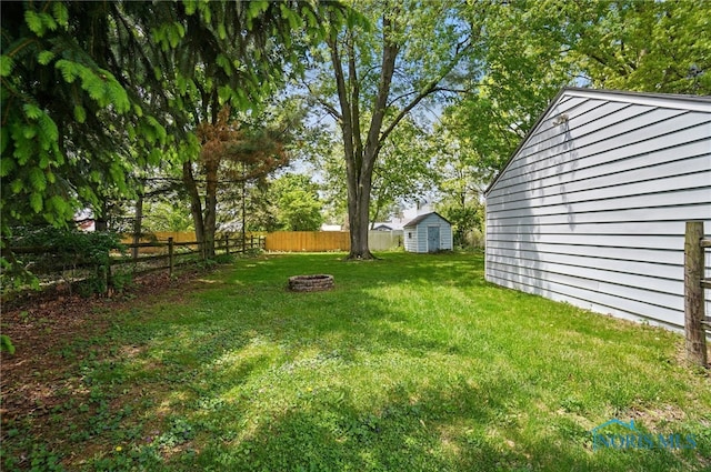 view of yard with an outdoor fire pit, a storage shed, and an outdoor structure
