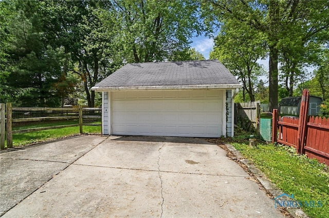 detached garage featuring fence