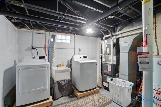 clothes washing area with washing machine and dryer and gas water heater
