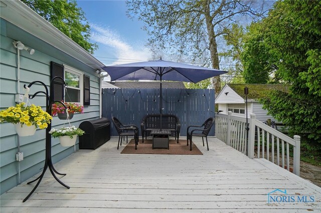deck featuring outdoor lounge area and fence